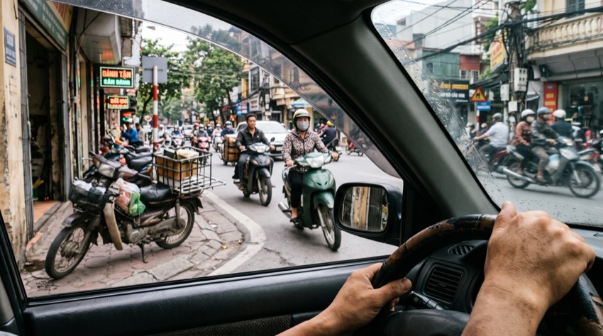 Tài xế dừng xe ở đầu hẻm quan sát dòng xe máy bên trái